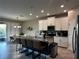 Spacious kitchen features granite counters, stainless appliances, an island with seating, and modern white cabinets at 11456 Short Story St, Orlando, FL 32832