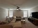 Spacious carpeted living room with a comfortable sectional sofa and a ceiling fan at 11456 Short Story St, Orlando, FL 32832