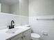 Bright bathroom with white tile, black faucet and white cabinets offers a clean, modern aesthetic at 1298 Scottsdale Dr, Ormond Beach, FL 32174