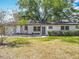 Beautiful front yard with green grass, flowering tree, and fresh exterior paint at 1298 Scottsdale Dr, Ormond Beach, FL 32174