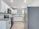 Bright kitchen features white cabinets, granite countertops, stainless steel appliances, and updated flooring at 1298 Scottsdale Dr, Ormond Beach, FL 32174