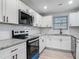 Updated kitchen features stainless appliances, granite countertops, and subway tile backsplash at 1298 Scottsdale Dr, Ormond Beach, FL 32174