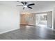 Bright open-concept living room featuring modern gray wood flooring and a stylish ceiling fan at 1298 Scottsdale Dr, Ormond Beach, FL 32174