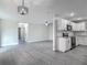 Open floor plan with gray wood flooring connects living spaces to the remodeled kitchen at 1298 Scottsdale Dr, Ormond Beach, FL 32174