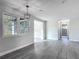 Open floor plan with gray wood flooring, modern light fixture and access to hallway at 1298 Scottsdale Dr, Ormond Beach, FL 32174
