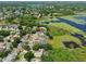 Aerial view shows a neighborhood with homes featuring solar panels, next to a lush lake at 1302 Shelter Rock Rd, Orlando, FL 32835
