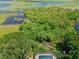 Expansive aerial shot of a home featuring a screened-in pool, lush greenery, and waterfront views at 1302 Shelter Rock Rd, Orlando, FL 32835