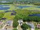 Aerial view of a neighborhood with homes backing onto a lake, featuring solar panels and screened pools at 1302 Shelter Rock Rd, Orlando, FL 32835