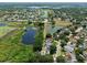 Aerial view showcasing neighborhood homes near a lake with lush greenery and solar panels at 1302 Shelter Rock Rd, Orlando, FL 32835