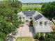 Aerial view of the home with solar panels on the roof surrounded by mature trees and a pond in the background at 1302 Shelter Rock Rd, Orlando, FL 32835