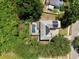 Aerial view of the backyard pool and solar panels set among mature trees at 1302 Shelter Rock Rd, Orlando, FL 32835