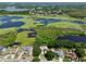 Aerial of a neighborhood showing homes with solar panels, near a lake with lush greenery at 1302 Shelter Rock Rd, Orlando, FL 32835