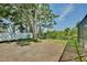 The backyard has mature shade trees, green grass and a white fence at 1302 Shelter Rock Rd, Orlando, FL 32835