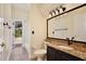 Granite countertop bathroom featuring a framed mirror and updated fixtures at 1302 Shelter Rock Rd, Orlando, FL 32835