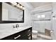 Bathroom with marble vanity, framed mirror, and updated shower with glass door at 1302 Shelter Rock Rd, Orlando, FL 32835