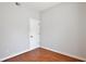 Cozy bedroom featuring wood floors, neutral paint, and a simple white door at 1302 Shelter Rock Rd, Orlando, FL 32835