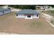 The back exterior of home featuring a pergola and a freshly seeded lawn at 13247 Sw 83Rd Cir, Ocala, FL 34473
