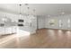 Open-concept living room with wood flooring, connecting to the kitchen and outdoor views at 13247 Sw 83Rd Cir, Ocala, FL 34473