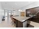 Open-concept kitchen with an island, seating, stainless steel appliances and view of the living room at 13865 Granger Ave, Orlando, FL 32827