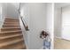 Carpeted staircase with wooden handrail, offering a safe and elegant transition between floors at 13865 Granger Ave, Orlando, FL 32827