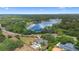 Aerial view of a luxurious lakeside home with a private pool surrounded by lush greenery at 1415 Brumley Rd, Chuluota, FL 32766