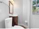 View of half bathroom with decorative mirror, toilet, sink, and access to outside at 1415 Brumley Rd, Chuluota, FL 32766