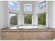 Elegant bathroom featuring a luxurious soaking tub with mosaic tile accents and multiple windows at 1415 Brumley Rd, Chuluota, FL 32766
