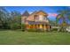 Charming home exterior featuring a covered porch, manicured landscaping, and unique architectural details at 1415 Brumley Rd, Chuluota, FL 32766