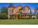 Charming home exterior featuring a covered porch, manicured landscaping, and unique architectural details at 1415 Brumley Rd, Chuluota, FL 32766