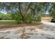 Expansive front yard with mature trees and circular driveway leading to a two-car garage at 1415 Brumley Rd, Chuluota, FL 32766