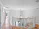 A view of the home's hallway with wood flooring and a decorative chandelier at 1415 Brumley Rd, Chuluota, FL 32766