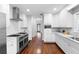 Bright, spacious kitchen featuring white cabinets, stainless steel appliances and hardwood floors at 1415 Brumley Rd, Chuluota, FL 32766