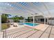 Inviting pool surrounded by a pergola, lush landscaping and a paver patio at 1415 Brumley Rd, Chuluota, FL 32766
