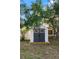Backyard storage shed painted white with gray doors offering ample storage space at 1415 Brumley Rd, Chuluota, FL 32766