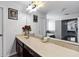 Bathroom vanity area with a long countertop, dark cabinets, and large mirror reflecting natural light and open space at 15210 Montesino Dr, Orlando, FL 32828