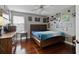 Well-lit bedroom featuring a wooden bed frame, laminated floors and fun decor on the walls at 15210 Montesino Dr, Orlando, FL 32828