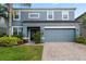 Charming two-story home featuring a well-maintained lawn, vibrant landscaping, and a two car garage at 15210 Montesino Dr, Orlando, FL 32828
