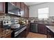 Lovely kitchen with dark wood cabinets, granite countertops, and stainless steel appliances at 15210 Montesino Dr, Orlando, FL 32828