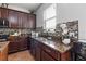 Modern kitchen with dark wood cabinets, granite countertops, and stainless steel appliances at 15210 Montesino Dr, Orlando, FL 32828