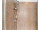 Close-up of a tiled shower with a mounted shower head and convenient shelving at 15210 Montesino Dr, Orlando, FL 32828