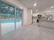 Bright kitchen opens to the pool area, featuring white cabinets and stainless steel appliances at 16742 Se 165Th Ave, Weirsdale, FL 32195