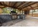 Well-equipped outdoor kitchen and entertainment area with a built-in grill and stone accents at 16742 Se 165Th Ave, Weirsdale, FL 32195