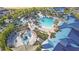 Aerial view of resort-style community pool and amenities, surrounded by palm trees and lush landscaping at 197 Jetty Way, Davenport, FL 33897