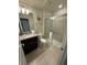 Well-lit bathroom with a granite vanity, toilet and tiled walk-in shower with a glass door at 197 Jetty Way, Davenport, FL 33897