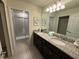 Bathroom featuring a dual sink vanity with granite countertop and tiled glass shower at 197 Jetty Way, Davenport, FL 33897