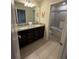Bathroom featuring a dual sink vanity with granite countertop and tiled glass shower at 197 Jetty Way, Davenport, FL 33897