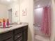 bathroom with pink polka dot shower curtain, granite countertop and vanity with princess artwork at 197 Jetty Way, Davenport, FL 33897