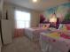 bedroom with two beds, castle mural, princess bedding, side tables, and natural light at 197 Jetty Way, Davenport, FL 33897
