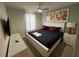 Cozy bedroom with light green walls, a bed with red pillows, and modern artwork at 197 Jetty Way, Davenport, FL 33897