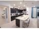 Modern kitchen features stainless steel appliances, a granite island with barstool seating, and dark cabinetry at 197 Jetty Way, Davenport, FL 33897